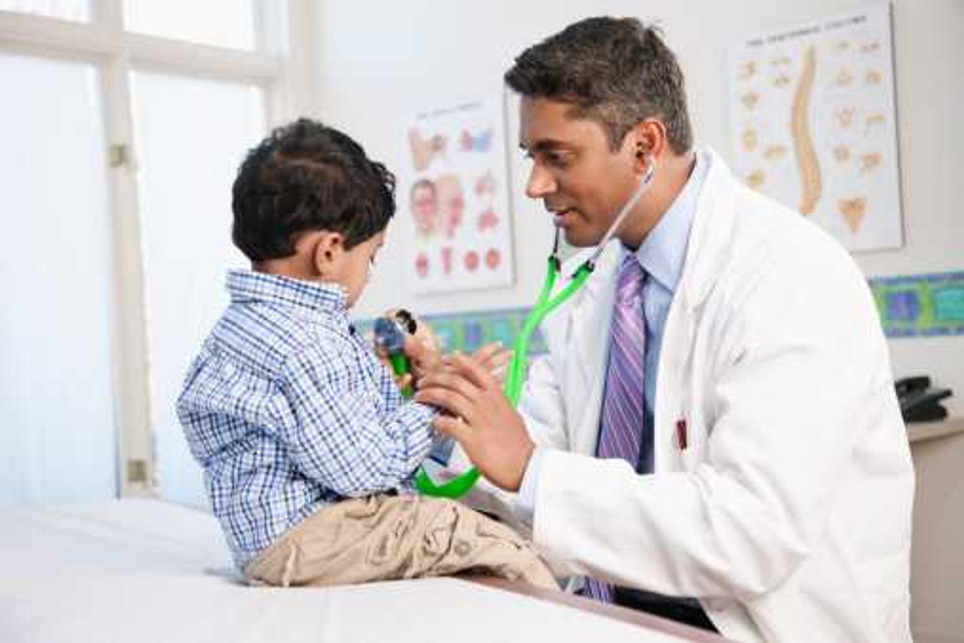 Pediatrician examining a young boy with a stethoscope at Opal Hospital